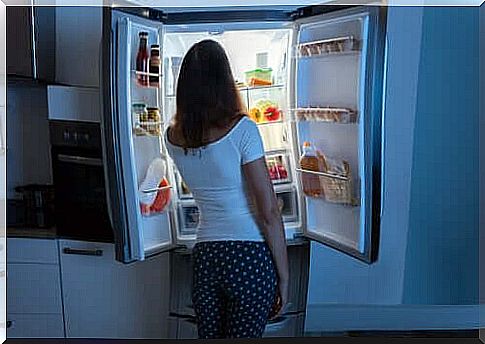 A woman looking in her refrigerator.