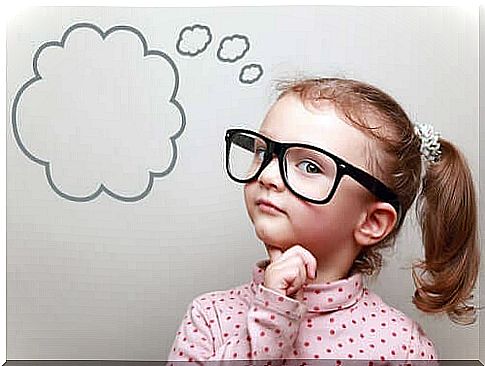 A young girl with glasses with a thought bubble painted on the wall next to her