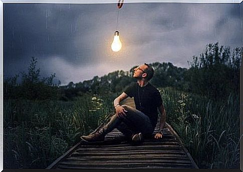 Man sitting under light bulb