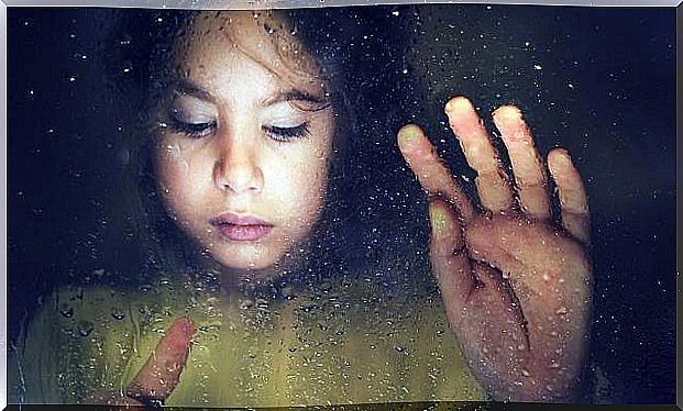 Girl holding hand against the window