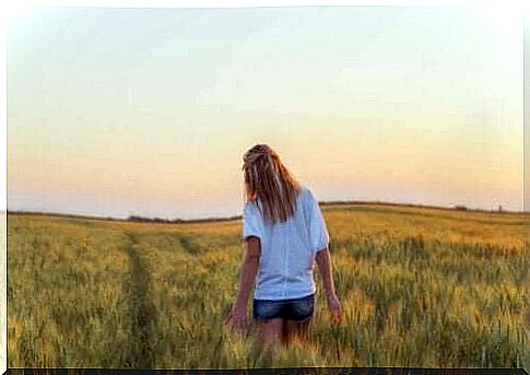 A woman is walking on a wheat field